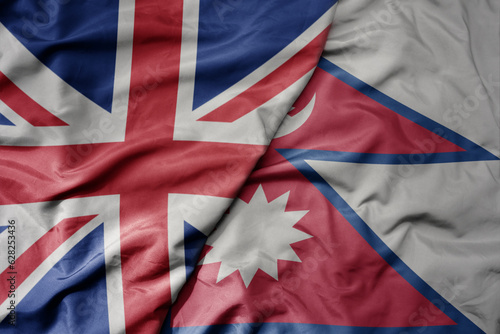 big waving national colorful flag of great britain and national flag of nepal .