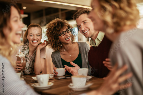 Diverse group of young people talking and having a coffee at a cafe