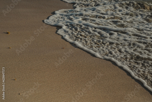 espuma de ola rompienso sobe la arena