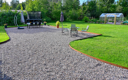 Back yard with seating area on gravel and lawn around