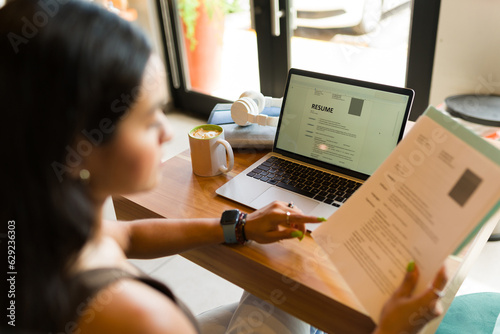 Rear view of a young woman working on her resume