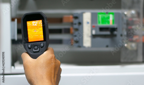 Professional Electrician use thermal infrared camera or thermometer scaning electrical system for preventive maintenance,Industrial thermography,Thermal image of power electric.