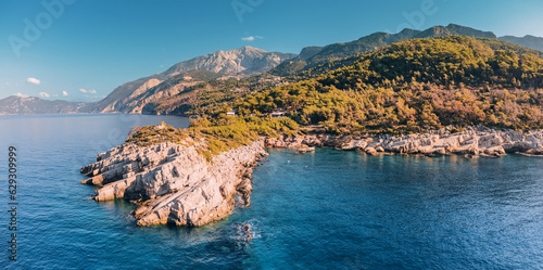 The aerial perspective provides a unique vantage point to appreciate the majestic collision of the rocky coastline and the relentless waves of the Aegean Sea.