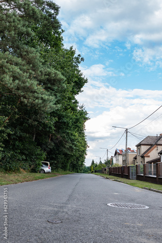 Droga ciągnąca się przez osiedle o letniej porze w obszarach podmiejskich zachodniej Polski 