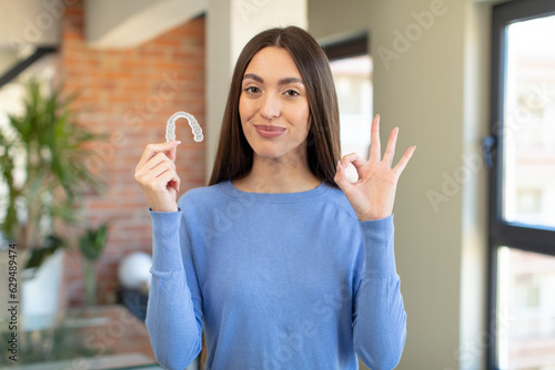 feeling happy, showing approval with okay gesture. dental retainer concept