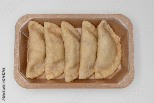 Envase con empanadillas crudas, listas para cocinar