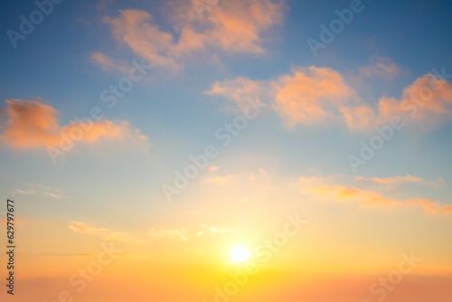 Pastel cloudscape. Sunrise sundown sky with gentle colorful clouds without any birds. With sun.