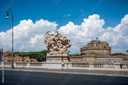 A woman strolled on Ponte Vittorio Emmanuelle nest to one of the bridge sculptures on the background