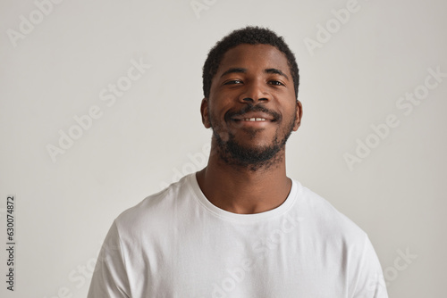 Minimal portrait of handsome black man posing in studio against white background