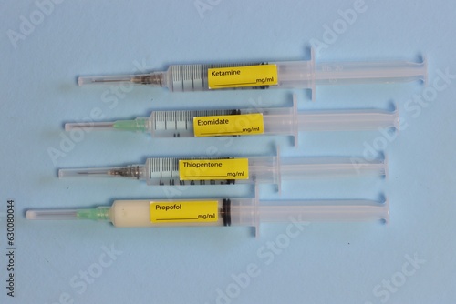 Different types of hypnotic drugs in a syringe with labels in a light blue background 