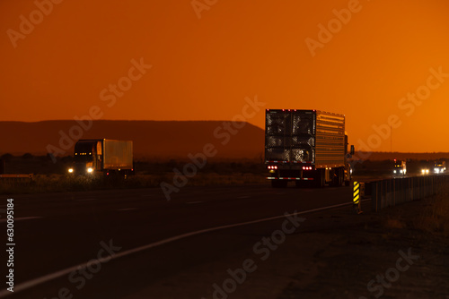 Freight delivery truck transporting cargo on interstate freeway at stunning sunset 