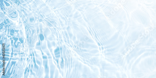 Water waves surface hits the sunlight (soft image). Blue swimming pool water background.