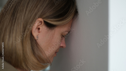 Desperate woman blunts against wall and worrying about problems at work. Employee is sad and faced difficulties