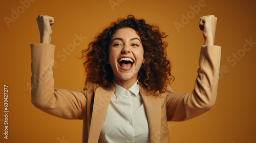 Joyful business woman freelancer entrepreneur smiling and rejoices in victory while sitting at desk and working at laptop after finishing project in home office