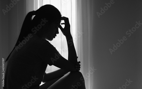 Young women sitting in dark room feeling pain with life problem. suffering from husband violence, Stop violence against and sexual abuse women, domestic violence, anti human trafficking.