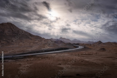 Landscape of a road in a deserted area under a cloudy sky in the evening