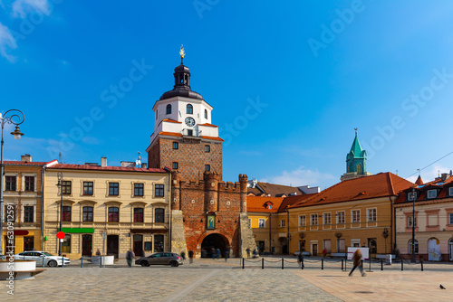Picturesque Lublin cityscape with historic symbol of city - medieval brick gate Brama Krakowska in sunny spring day, Poland