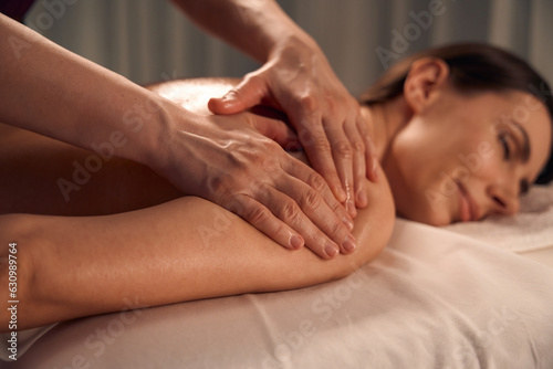 Spa patient sleeping during upper arm massage session