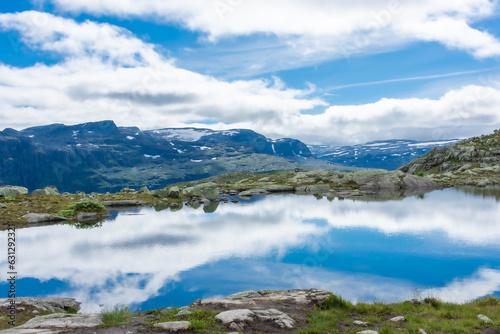 Amazing reflection over a lake in the mountains of Trolltunga hike, Norway