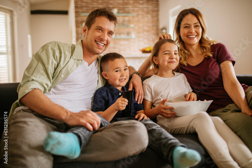 Young family watching the tv on the couch in the living room at home