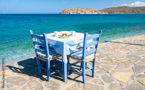 Crete Greece Plaka Lassithi, a traditional blue table and chairs on the beach in Crete Greece. Paralia Plakas, Plaka village Crete. 
