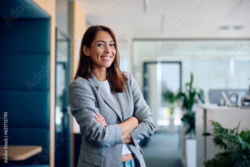 Happy confident businesswoman in office looking at camera.