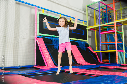 Excited kid jumping in the trampoline area in the playroom