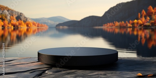 Empty round black podium on stone platform with autumn lake and forest background for product display.