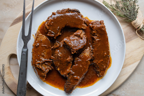 Traditional braised beef roast with brown gravy sliced ​​and warm on a plate