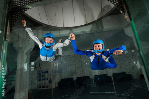 A man and a woman enjoy flying together in a wind tunnel. Free fall simulator