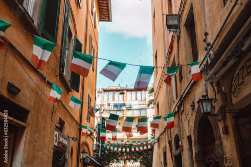 Holiday in the Italian city of streets with Italian flags and ancient buildings. Pisa, Italy. High quality photo