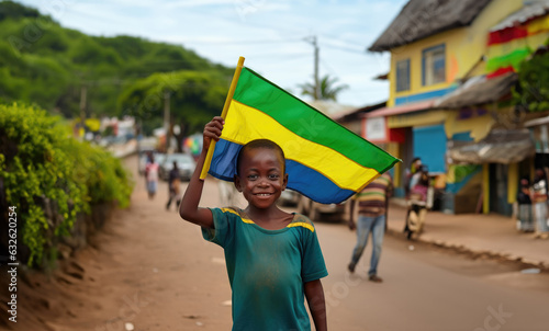 Un garçon gabonais tenait un drapeau de la république du Gabon dans sa main, dans une rue de Libreville