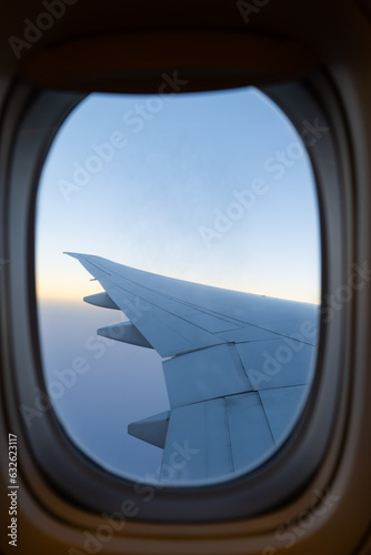 View of airplane wing with blue sky from a window
