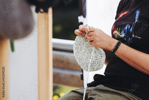 Mains d'une femme en train de tricoter avec des aiguilles