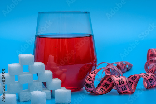 Czerwony słodki napój owocowy z dużą ilością dodanego białego cukru