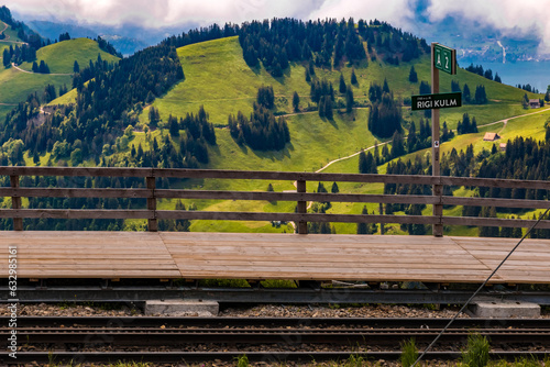 Nice view of the Rigi Kulm cogwheel railway mountain station with a lovely mountainous landscape in the back. The wooden platform has a sign that shows that the station is 1748 meters above sea level.