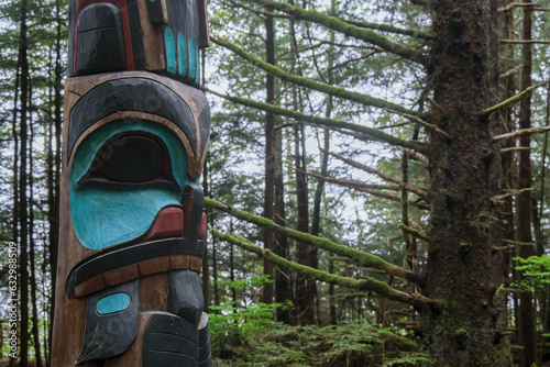 Tlingit totem poles and lush woods tree nature landscape scenery in Sitka Historical Park hiking trails with creeks, green bushes and vegetation in magic fairytale environment Baranof Island