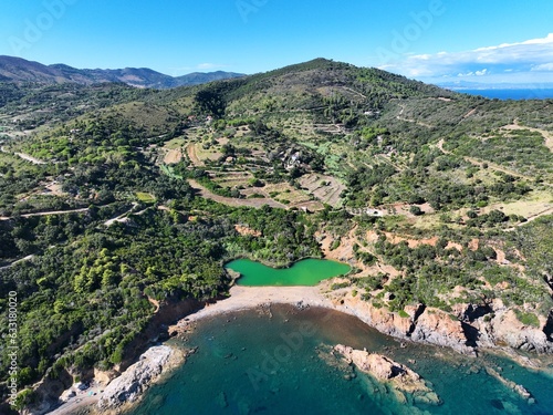 Aerial view of Terranera lake, a pond with emerald green water of sulfur origin between the village of Porto Azzurro and on Elba Island, Tuscany, Italy