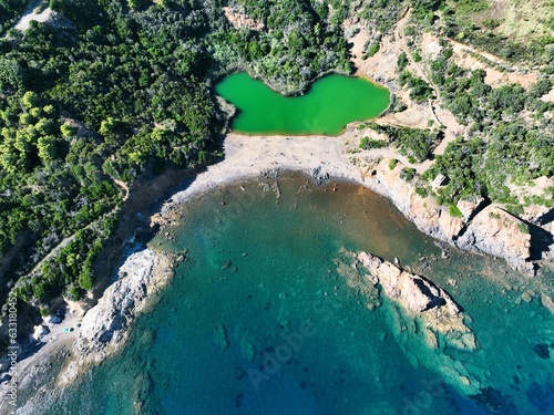 Aerial view of Terranera lake, a pond with emerald green water of sulfur origin between the village of Porto Azzurro and on Elba Island, Tuscany, Italy