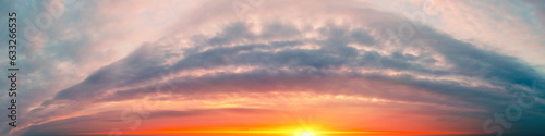 Fantastic panorama of dramatic cloudy blazing sky in the evening. Clouds in shape arch. Colorful cloudy sky at sunset. Gradient color. Sky texture. Abstract nature background