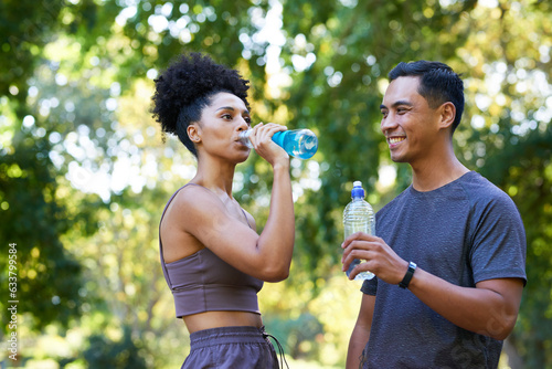 Fitness team cools down after exercise in park, beautiful couple drinking water 