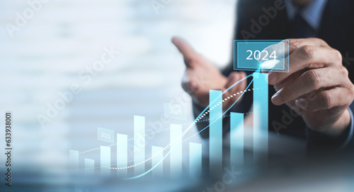 Businessman touching on business growth graph for year 2023 to 2024. new business goals, plans and strategy. Business Development concept