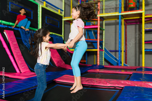 Little girls jumping in the trampoline area of the playroom