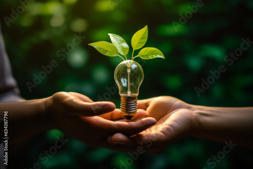 Creative concept of sustainability: Hand holding a light bulb with green leaves