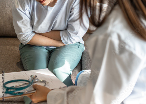 Abdominal pain patient woman having medical exam with doctor on illness from stomach cancer, irritable bowel syndrome, pelvic discomfort, Indigestion, Diarrhea, GERD (gastro-esophageal reflux disease)