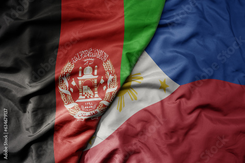 big waving realistic national colorful flag of afghanistan and national flag of philippines .