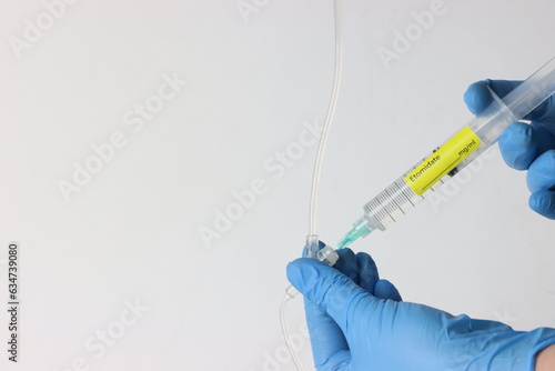 Professional wearing gloves injecting Etomidate into a intravenous set.