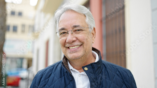 Middle age man with grey hair smiling confident at street