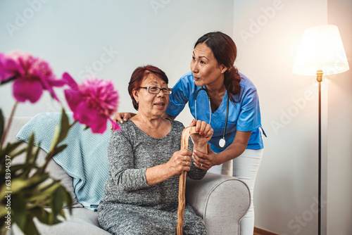 Caregiver, carer hand holding elder hand woman in hospice care. Philanthropy kindness to disabled concept.Public Service Recognition Week. Attentive young doctor talks with female patient