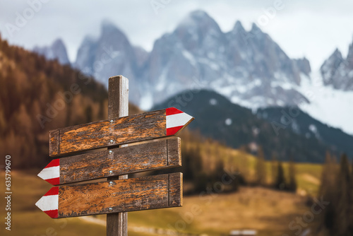 Scenic view of the Dolomites, Italy. Wooden signpost in front of rough Alpine mountain range in the background. Concept of hiking adventures.